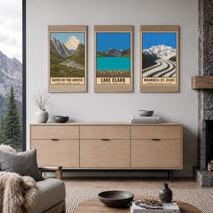 Pu&ograve; includere: Tre stampe d'arte verticali incorniciate che raffigurano i parchi nazionali dell'Alaska. La stampa a sinistra mostra Gates of the Arctic, quella centrale Lake Clark e quella a destra Wrangell-St. Elias. Ogni stampa presenta un'illustrazione.