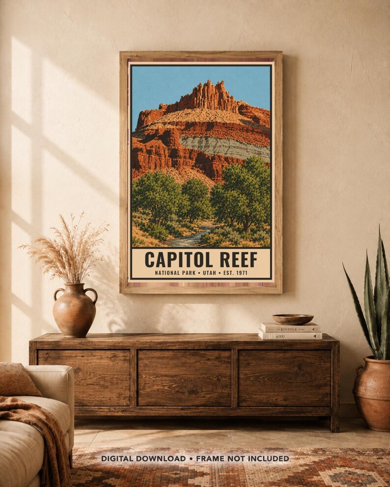 May include: A vertical wall art print featuring a landscape illustration of Capitol Reef National Park in Utah. The image displays red rock cliffs, green trees, and a stream under a blue sky, with the text CAPITOL REEF NATIONAL PARK UTAH EST. 1971.