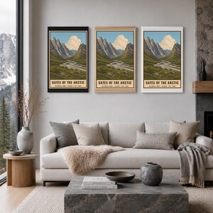 Może przedstawiać: Trzy pionowe wydruki ścienne przedstawiające ilustrację krajobrazu Parku Narodowego Gates of the Arctic na Alasce. Każdy wydruk ukazuje pasmo g&oacute;rskie, wijącą się rzekę i niebieskie niebo z chmurami, z napisem GATES OF THE ARCTIC.