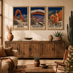 May include: Three framed wall art prints featuring illustrations of Arches, Canyonlands, and Bryce Canyon National Parks. Each print depicts a snowy landscape under a starry night sky with a decorated Christmas tree in the foreground.