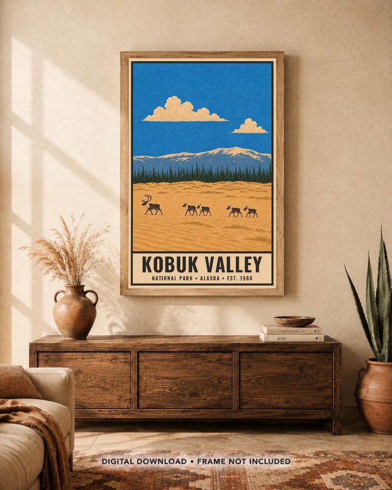 Pu&ograve; includere: Una stampa artistica rettangolare da parete con un'illustrazione paesaggistica del Parco Nazionale della Kobuk Valley in Alaska. La scena raffigura un terreno sabbioso color marrone chiaro con un branco di carib&ugrave;, una foresta verde scuro e montagne innevate.
