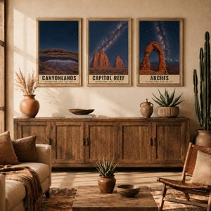 May include: Three vertical wall art prints featuring night sky landscapes of Canyonlands, Capitol Reef, and Arches National Parks. Each print displays a dark blue starry sky above red rock formations with black text labels at the bottom.