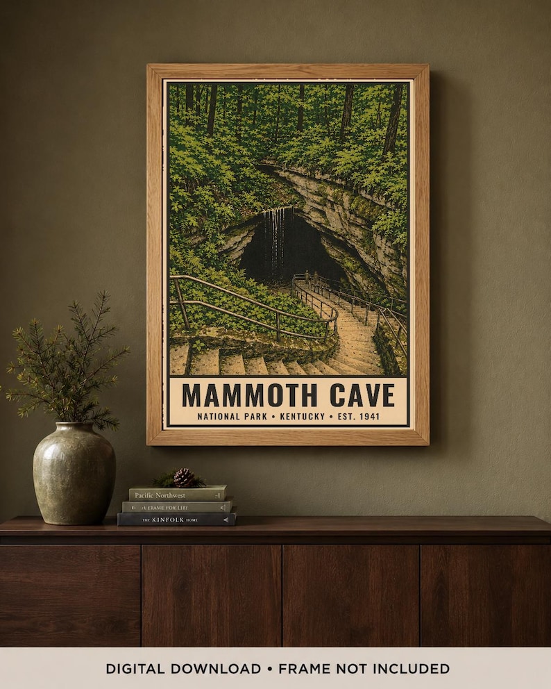 May include: A framed vertical poster featuring a detailed illustration of the Mammoth Cave entrance in Kentucky, with stone stairs, metal railings, and lush green forest foliage. The text reads MAMMOTH CAVE NATIONAL PARK KENTUCKY EST. 1941.