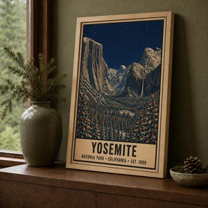 May include: A framed vertical poster featuring a nighttime illustration of Yosemite National Park with snow-capped mountains, a starry sky, and evergreen trees decorated with colorful lights. The text reads YOSEMITE NATIONAL PARK CALIFORNIA EST. 1890.