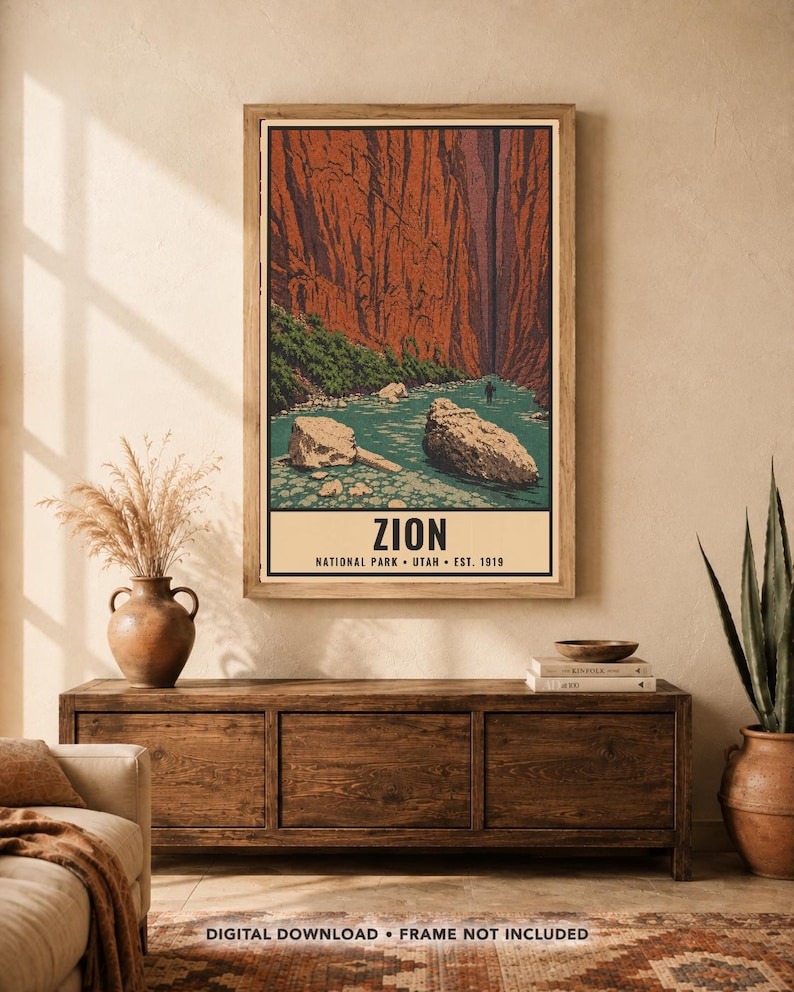 Może przedstawiać: Pionowy wydruk ścienny przedstawiający stylizowaną ilustrację Parku Narodowego Zion z wysokimi czerwonymi ścianami kanionu, turkusową rzeką i dużymi głazami. Tekst głosi ZION NATIONAL PARK UTAH EST. 1919. Oprawiony w drewnianą ramę.