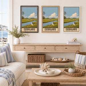 K&ouml;nnte beinhalten: Drei vertikale Wandkunstdrucke mit einer Landschaftsillustration des Everglades-Nationalparks mit einem wei&szlig;en Reiher in einem grasbewachsenen Sumpf, blauem Himmel und Wolken. Jeder Druck enth&auml;lt den Text EVERGLADES NATIONAL PARK FLORIDA EST. 1947.