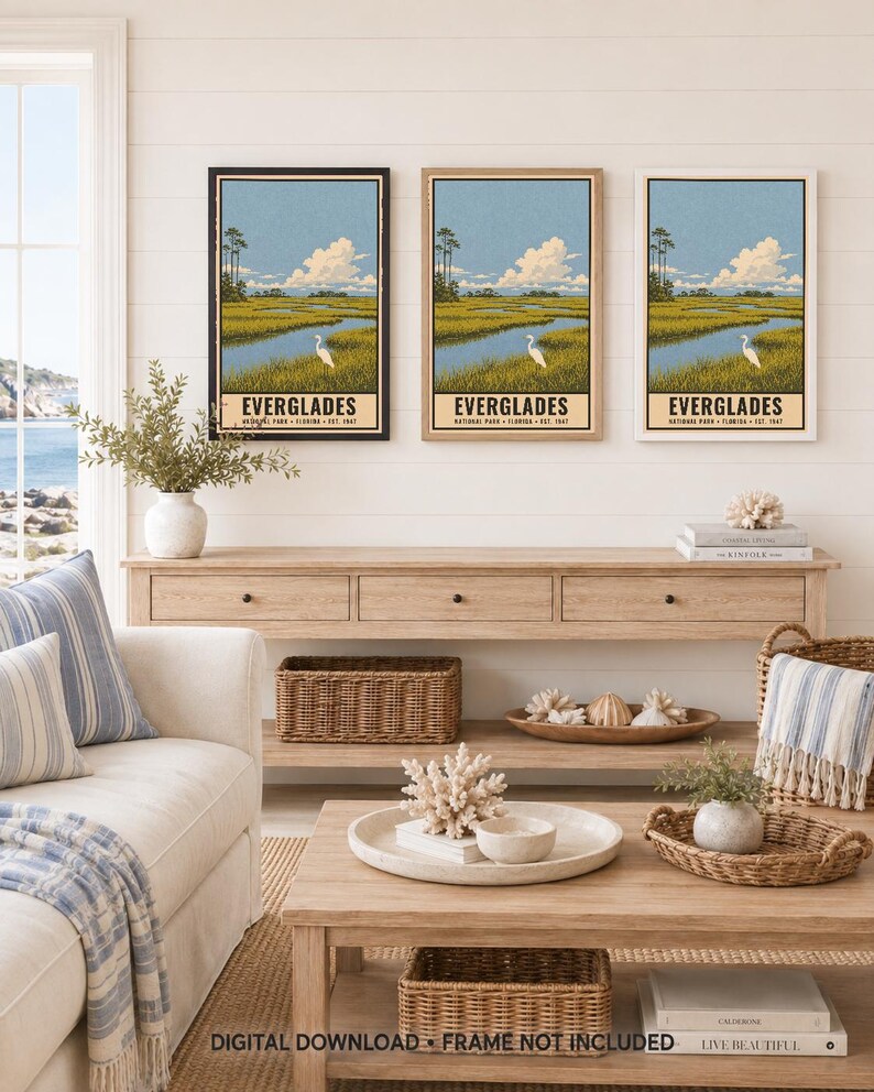 K&ouml;nnte beinhalten: Drei vertikale Wandkunstdrucke mit einer Landschaftsillustration des Everglades-Nationalparks mit einem wei&szlig;en Reiher in einem grasbewachsenen Sumpf, blauem Himmel und Wolken. Jeder Druck enth&auml;lt den Text EVERGLADES NATIONAL PARK FLORIDA EST. 1947.