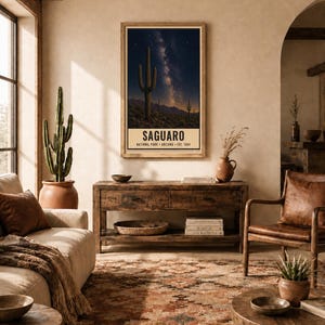 Puede incluir: Una l&aacute;mina de arte mural vertical enmarcada que muestra un cielo nocturno con la V&iacute;a L&aacute;ctea sobre un paisaje des&eacute;rtico con cactus Saguaro. El texto en la parte inferior dice SAGUARO NATIONAL PARK ARIZONA EST. 1994. La l&aacute;mina tiene un marco de madera.
