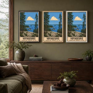 Op de afbeelding: Drie identieke verticale wandkunstprints met een landschap van Voyageurs National Park, Minnesota. Elke print toont een blauw meer, een rotsachtige kustlijn, hoge dennenbomen en een wolk, met de tekst VOYAGEURS NATIONAL PARK MINNESOTA EST. 1975.