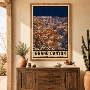 Puede incluir: Un p&oacute;ster vertical enmarcado que representa el Gran Ca&ntilde;&oacute;n en Arizona bajo un cielo estrellado. Las paredes del ca&ntilde;&oacute;n est&aacute;n cubiertas de nieve y un &aacute;rbol de Navidad decorado con luces de colores se alza en primer plano. El texto dice GRAND CANYON.