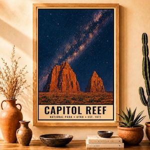 May include: A framed vertical wall art print featuring a night sky with a visible Milky Way galaxy over the red rock formations of Capitol Reef National Park in Utah. The text at the bottom reads CAPITOL REEF NATIONAL PARK &bull; UTAH &bull; EST. 1971.