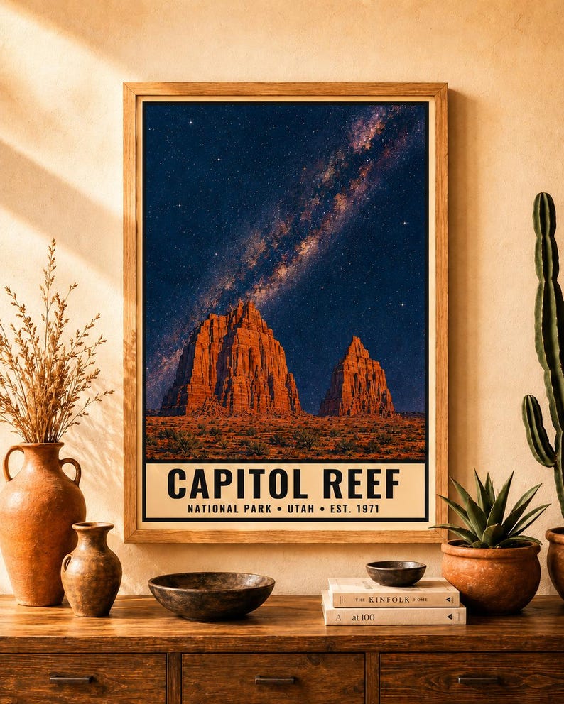 May include: A framed vertical wall art print featuring a night sky with a visible Milky Way galaxy over the red rock formations of Capitol Reef National Park in Utah. The text at the bottom reads CAPITOL REEF NATIONAL PARK &bull; UTAH &bull; EST. 1971.