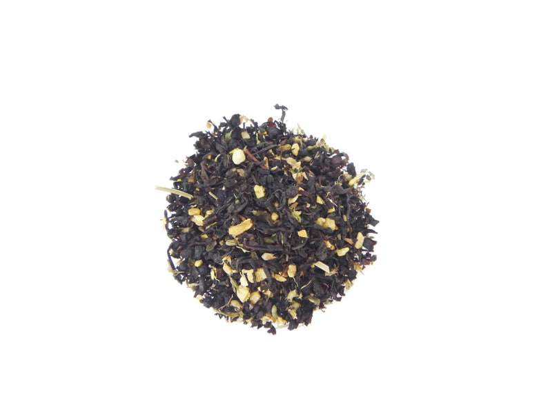 May include: A close-up of a pile of black tea leaves with small pieces of dried citrus fruit.