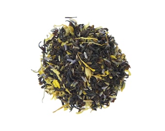 May include: A close-up of a blend of black tea leaves, lavender buds, and yellow citrus peel. The tea leaves are dark brown and the lavender buds are a light purple. The citrus peel is a bright yellow.