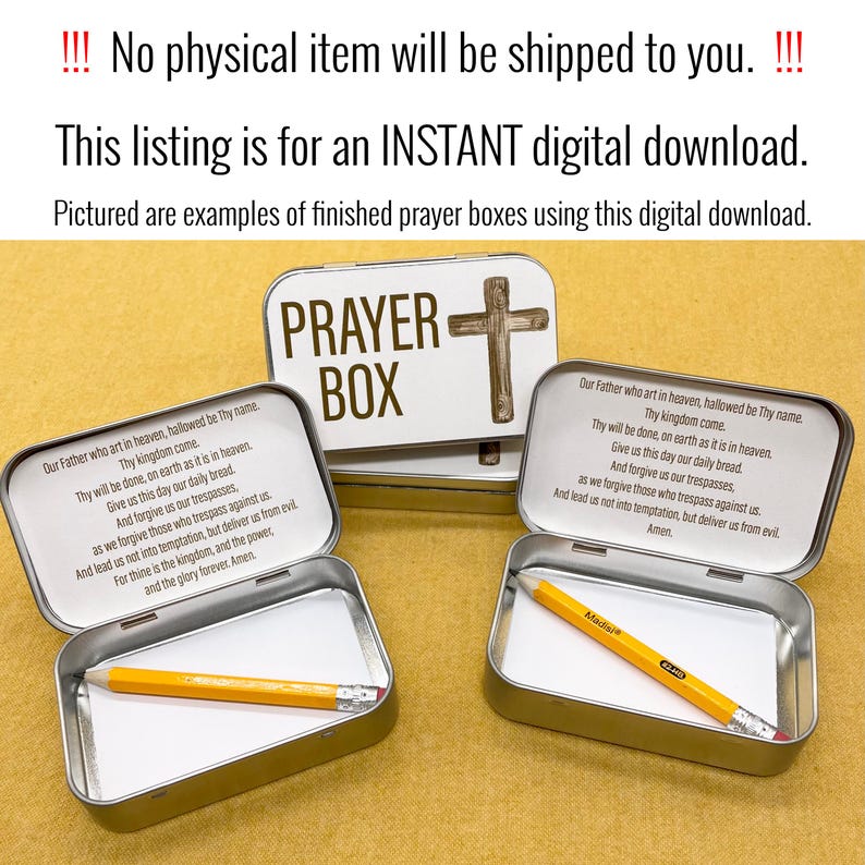 May include: Two silver metal boxes with a white background and the words "PRAYER BOX" printed in brown. The boxes are open and contain a white piece of paper and a yellow pencil. The boxes have a cross design on the lid.