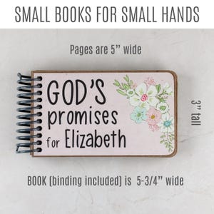 May include: A small, spiral-bound book with the text "GOD'S promises for Elizabeth" on a pink background. The cover features floral illustrations. The book is 5-3/4 inches wide, 3 inches tall, and the pages are 5 inches wide.