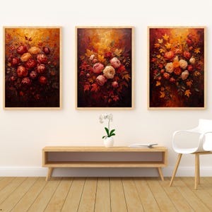 Pode incluir: Três impressões de arte de parede retangulares com pinturas a óleo de buquês de flores em tons de vermelho profundo, laranja e amarelo. Cada impressão é emoldurada em madeira clara, exibindo rosas e folhas de outono em fundos escuros.