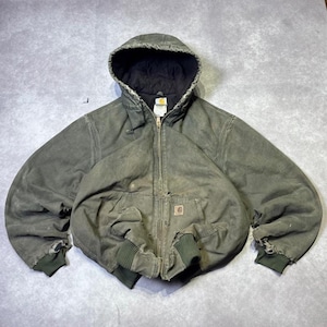 May include: A distressed olive green hooded jacket featuring a full-length front zip, a black quilted interior lining, and ribbed knit cuffs. The garment includes a small square logo patch on the front pocket and shows visible wear and fraying.