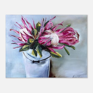 Puede incluir: Una pintura al óleo que representa un ramo de flores protea de color rosa y blanco vibrante con hojas verdes dispuestas en un cubo blanco sencillo. El fondo es de un gris suave y una firma es visible en la esquina inferior derecha.