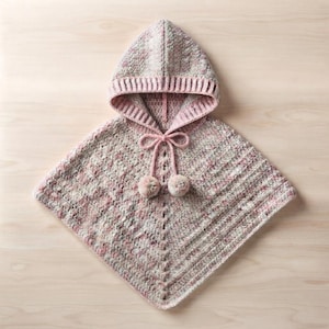 Può includere: Un poncho con cappuccio realizzato in filato variegato nei toni del rosa tenue, crema e grigio chiaro. Il capo presenta un bordo a coste lungo l'apertura del cappuccio, un motivo a punti verticali testurizzati e due cordini con pon-pon.