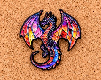 Puede incluir: Un pin de esmalte metálico con forma de dragón con las alas extendidas. El dragón presenta un efecto de vidriera con colores vibrantes inspirados en galaxias, incluyendo morado, rosa, naranja y azul, delineado en metal negro.