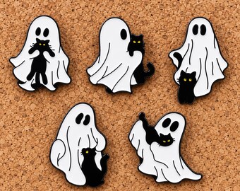 Puede incluir: Cinco pines de esmalte que muestran fantasmas blancos cubiertos con sábanas, cada uno interactuando con un pequeño gato negro de ojos amarillos. Los fantasmas tienen ojos ovalados negros simples y los gatos aparecen en varias posturas, incluyendo sentados o siendo sostenidos.