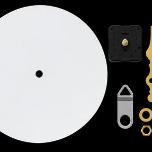 May include: A circular white clock face blank with a center hole, accompanied by a black clock movement mechanism, three gold-colored ornate clock hands, a silver metal wall hanger, a gold-colored washer, and a gold-colored hexagonal nut.