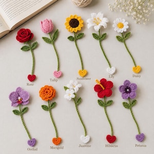 May include: A collection of ten crocheted flower bookmarks, each featuring a unique bloom including a rose, tulip, sunflower, lily, daisy, orchid, marigold, jasmine, hibiscus, and petunia, all with green stems and small heart-shaped ends.