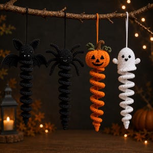 May include: Four crocheted Halloween hanging ornaments featuring a black bat, a black spider, an orange pumpkin with a green stem, and a white ghost. Each figure is attached to a long, spiraling, color-coordinated crocheted tail for hanging.