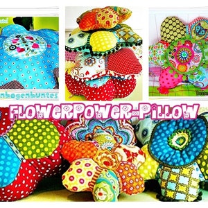 Könnte beinhalten: Buntfarbene, blumenförmige Kissen mit verschiedenen Mustern und Texturen. Die Kissen sind aus Stoff gefertigt und haben einen 3D-Effekt. Die Kissen sind in Form einer Blume angeordnet und haben ein helles und fröhliches Design.