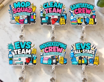 May include: Six retractable badge reels featuring colorful illustrations of cleaning supplies and equipment. Each reel displays text including Mop Squad, Clean Team, Sanitation Crew, EVS Team, Housekeeping Crew, and EVS All Stars with cleaning slogans.