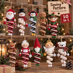 May include: Ten felt Christmas ornaments hanging from a wooden branch, including Santa, a snowman, a penguin, a gingerbread person, an elf, a reindeer, Mrs. Claus, a gnome, an angel, and a polar bear, each with a spiral base and hanging twine.