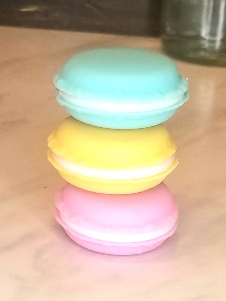 Puede incluir: Pila de tres macarons de color pastel. El macaron de arriba es azul claro, el macaron del medio es amarillo y el macaron de abajo es rosa.