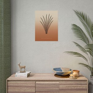 May include: A rectangular wall art print featuring a black line drawing of a seagrass plant centred on a gradient background that transitions from light beige at the top to a warm terracotta orange at the bottom with the text SEAGRASS.