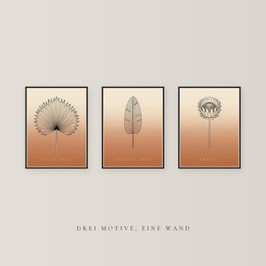 May include: A set of three framed wall art prints featuring black line drawings of a palm leaf, a banana leaf, and a protea flower. Each print has a gradient background transitioning from light beige to terracotta orange.