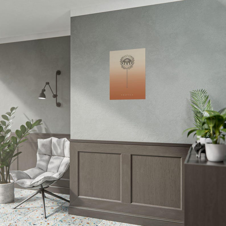 Pu&ograve; includere: Una stampa artistica da parete rettangolare con un disegno a linee nere di un fiore di protea centrato su uno sfondo a gradiente verticale che sfuma dal beige chiaro in alto all'arancione terracotta scuro in basso con la parola PROTEA.