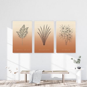 Peut inclure: Un ensemble de trois affiches murales rectangulaires pr&eacute;sentant des dessins au trait noir de pampas, d'herbes marines et de bambou. Chaque affiche a un fond d&eacute;grad&eacute; passant du cr&egrave;me clair en haut &agrave; un orange terre cuite chaud en bas.