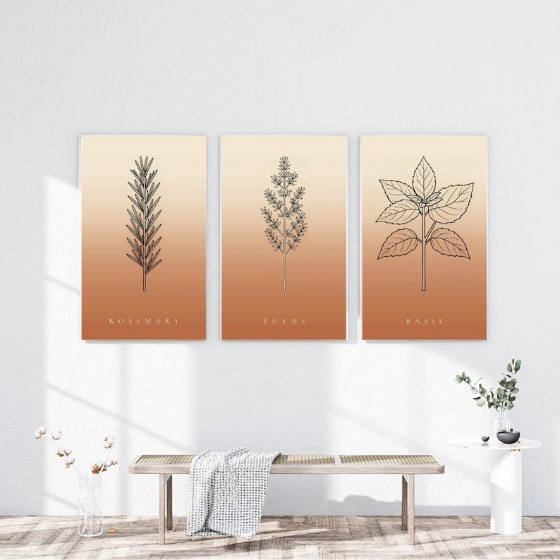 Op de afbeelding: Een set van drie rechthoekige wandposters met zwarte lijntekeningen van rozemarijn, tijm en basilicumplanten. Elke print heeft een verticale gradi&euml;ntachtergrond die verloopt van lichtcr&egrave;me aan de bovenkant naar warm terracotta-oranje onderaan.