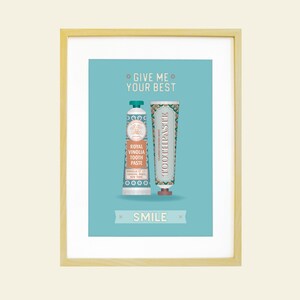 May include: A light blue poster with a white frame featuring two tubes of toothpaste. The text on the poster reads "Give me your best" and "Smile".