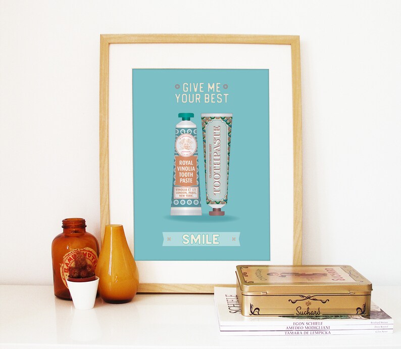 May include: A framed print with a light blue background featuring two vintage toothpaste tubes with the text "Give me your best" and "Smile".