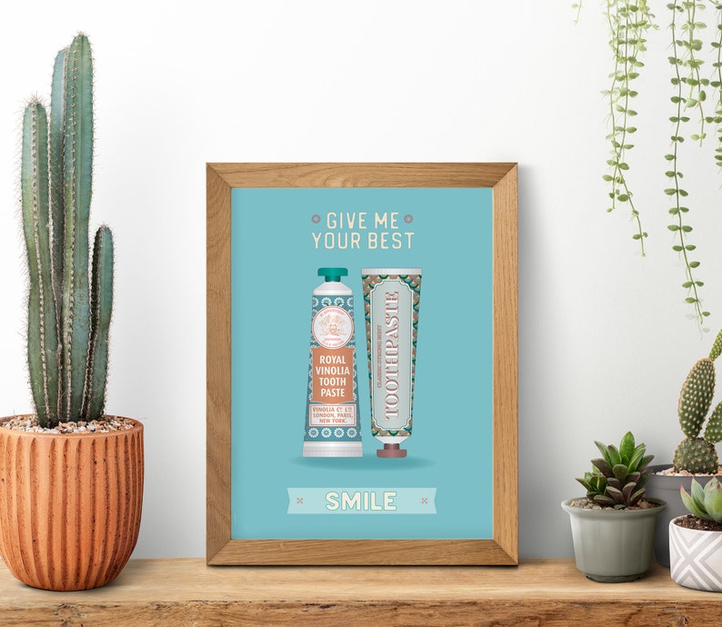 May include: A framed print with a blue background and the text "Give me your best smile" in white. Two tubes of toothpaste are shown, one with the text "Royal Vinolia Tooth Paste" and the other with the text "Classic Toothpaste".