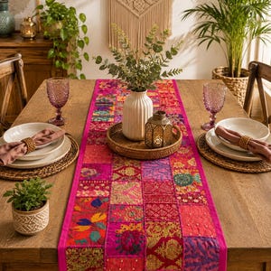 Peut inclure: Un chemin de table rectangulaire aux couleurs vives, composé d'un assemblage de tissus brodés dans des tons rose, magenta, rouge et doré. Le chemin est orné de motifs floraux complexes, de paillettes et de fils métalliques.