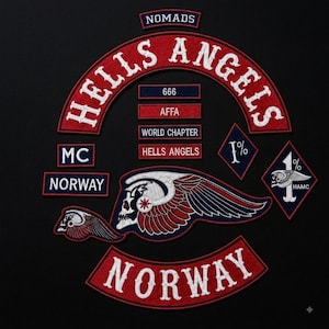 Puede incluir: Una colección de parches bordados con el texto HELLS ANGELS, NOMADS, MC, NORWAY, 666, AFFA, WORLD CHAPTER y 1%. El conjunto incluye un emblema grande de calavera alada, una calavera alada más pequeña y parches en forma de diamante con símbolos 1%.