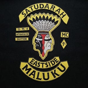 May include: A set of embroidered patches featuring the Satudarah logo with a central dual-faced figure in black, white, and red, topped with a feathered headdress. The yellow and black text includes SATUDARAH, EASTSIDE, MALUKU, 13-95-4, and MC.