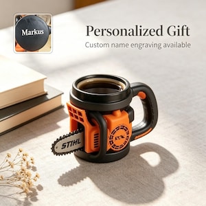 May include: A black and orange mug shaped like a chainsaw with a handle, a protruding bar, and a chain detail. The side features a circular vent design and the text STIML on the bar. An inset shows a black circular lid with the name Markus engraved.
