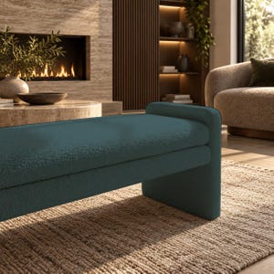 May include: A teal-colored bench featuring a textured, fabric-covered surface with a rounded, continuous design that forms both the seat and the side support. The bench has a solid, low-profile structure with clean lines and a soft, matte finish.