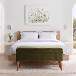 Peut inclure: Un banc de rangement rectangulaire en velours vert olive doté de quatre pieds en bois fuselés, placé au pied d'un cadre de lit en bois. Le lit est recouvert d'une parure blanche à fines rayures bleues, avec une tête de lit et une illustration florale.