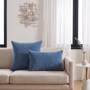 May include: Two blue corduroy throw pillows, one square and one rectangular, featuring a vertical ribbed texture. The pillows are displayed together, showcasing the soft fabric and deep blue color, providing a consistent look for home decor.