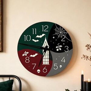 May include: A round wall clock featuring a segmented face in dark green, black, red, and gray. The design includes white numerals, a central tower illustration, flying bats, a spider web, holly sprigs, and small skull icons with black hands.