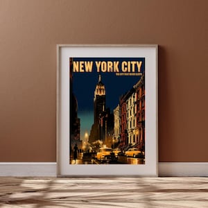 May include: A framed art print featuring a night scene of New York City with the text NEW YORK CITY THE CITY THAT NEVER SLEEPS. The image displays a tall skyscraper, brownstone buildings, and yellow taxis on a street under a dark blue sky.
